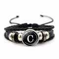 Dettaglio macro del bracciale rétro multistrato in pelle intrecciata con lettera C - Lettera C
