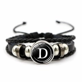 Dettaglio del bracciale multistrato in pelle intrecciata con perle e ciondolo lettera D - Lettera D