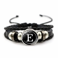 Detail of multilayer woven leather bracelet featuring a glass cabochon with letter E - Letter E