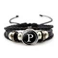 Close-up of multilayer punk bracelet featuring woven leather and a glass letter P charm - Letter P