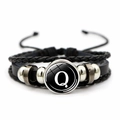 Macro detail of multi-layer leather bracelet with letter Q charm and metallic beads - Letter Q
