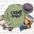 Flat lay of green 'I smell snow' sweatshirt with casual winter accessories on wood - S / Olive Green (Black Font)