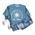 Flat lay of blue sweatshirt featuring sunflower print and Be Kind slogan with jeans - Blue Sweatshirt (White Text Pattern)