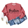 Gros plan du sweat-shirt rouge avec l'imprimé texte Positive Mind Vibes Life - S / Rouge (Police Noire)