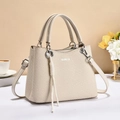 Elegant beige textured large capacity handbag with metal ring handles and tassel detail - Off White