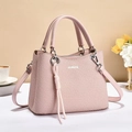 Detailansicht der rosa geflochtenen Handtasche mit Fransenquaste und verstellbarem Schultergurt - Rosa