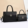 Close-up of black lychee grain leather handbag set with vertical pleated texture and metal buckle - Black