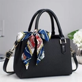 Détail du sac à main noir texturé avec boucles dorées et foulard en soie coloré décoratif - Noir
