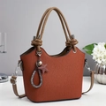 Orange brown pleated tote bag with cylindrical handles and star charm on a white table - Earthy Yellow