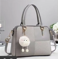 Detail of grey paneled tote bag with checkered fabric textures and plush monster charm - Gray