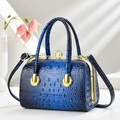 Détail d'un sac à main bleu foncé motif crocodile avec cadre doré et fermoir perle - Bleu