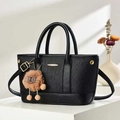 Detail of black tote bag featuring vertical stripes texture and a cute plush charm - Black
