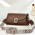 Brown lychee leather crossbody bag with geometric woven strap on a white stand - Coffee