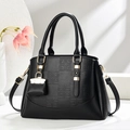 Elegant black embossed tote bag with dual handles and adjustable strap on a white background - Black