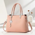 Detail of pink crossbody bag with litchi texture and silver pearl knot charm - Pink
