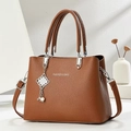 Brown lychee leather crossbody bag with top handles and pearl knot pendant - Earthy Yellow