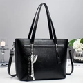 Detailed view of black faux leather tote bag with sneaker charm and adjustable strap - Black