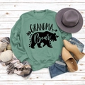 Flat lay of green Grandma Bear sweatshirt with autumn decor on white wood background - S / Light Green (Black Text)