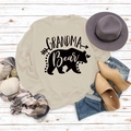 Flachbild des Grandma Bear Sweatshirts mit sandfarbenem Stoff und Zubehör auf Holzboden - S / Sand (Schwarze Schrift)