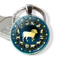 Macro detail of Aries zodiac glass cabochon keychain with gold constellation symbols - Aries