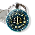 Macro view of Libra zodiac glass pendant keychain with constellation dial and silver frame - Libra