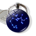 Macro view of Sagittarius constellation glass pendant keychain with polished silver metal base - Sagittarius