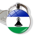 Detail of Lesotho flag keychain with a glass cabochon pendant next to a silver key - Lesotho
