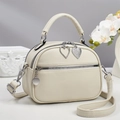 Détail du sac en cuir litchi blanc crème avec breloques de fermeture en cœur diamant - Blanc Cassé
