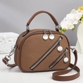 Close-up of brown woven texture handbag with silver round zippers and sleek metal hardware - Brown