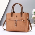 Detail of tan leather tote bag featuring a front zipper pocket with silver chain decoration - Earthy Yellow