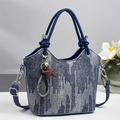 Blauwe denim bucket bag met geometrische lijnen en sterhanger voor dames in een studio-opname - Donkerblauw