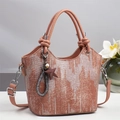 Detail der rosabraunen Beuteltasche mit geometrischer Textur, Sternanhänger und Silber-Hardware - Altrosa