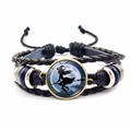 Detail eines Halloween-Lederarmbands mit einem Glasanhänger mit Hexensilhouette - Hexe auf Besen Stil (JY002591-2)