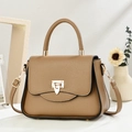 Close-up of tan leather handbag showing fine litchi texture and golden swivel lock - Brown