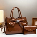 Brown crocodile patent leather tote bag with a rhinestone bow in a warm indoor setting - Coffee