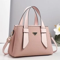 Detailed view of pink textured tote bag with black triangle metal clasp and dual handles - Pink