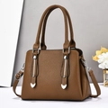 Detail of brown litchi pattern leather handbag with silver bars and heart accents - Dark Khaki