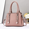 Detail of pink lychee leather handbag with silver vertical metal trim and heart studs - Pink