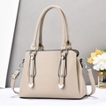 Elegant beige pebbled leather handbag with metal accents and adjustable shoulder strap - Light Khaki