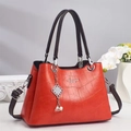 Détail du sac à main rouge motif crocodile avec ferrures argentées et pendentif perle - Rouge