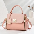 Pink crossbody bag in lychee pattern leather with a golden M clasp on white stand - Pink