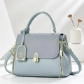 Detail of light blue crossbody bag with woven texture flap and gold metal hardware - Blue