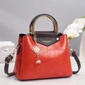 Borsa rossa trama coccodrillo con manici dorati e nappa su espositore elegante - Rosso