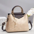 Detailed macro of a beige stone-patterned handbag featuring gold handles and orchid decor - Khaki
