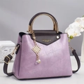 Detail of lavender crocodile texture bag with gold handle and pearl tassel charm - Taro Purple