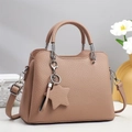 Close-up of pink lychee grain leather handbag with star charm and silver hardware - Purple