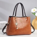 Elegant brown crocodile pattern tote bag with gold lettering and pearl pendant detail - Earthy Yellow