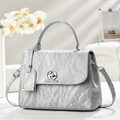 Detail of silver-grey handbag with unique pleated texture and oval metallic turn-lock - Blue