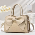 Close-up of cream crossbody bag featuring a large bow and crocodile embossed texture - Khaki