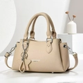 Close-up of beige lychee grain leather texture with silver star chain on a chic handbag - Light Khaki